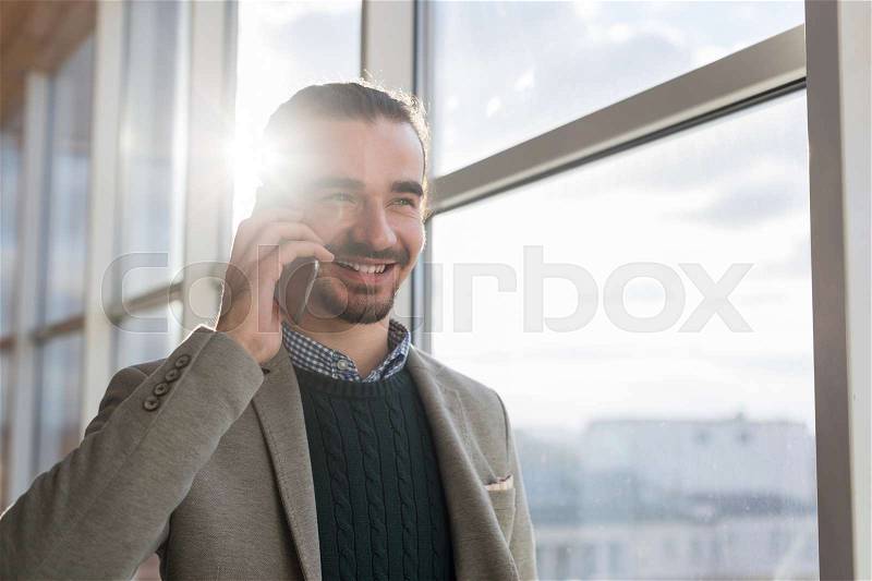Business Man Talking On Mobile Phone Call Standing in front Panoramic Window Businessman In Coworking Center Modern Office Interior, stock photo