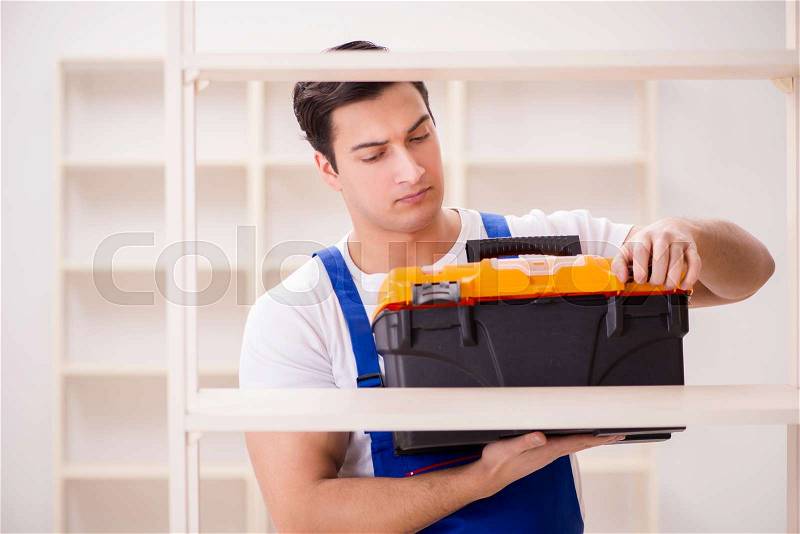 Worker man repairing assembling bookshelf, stock photo