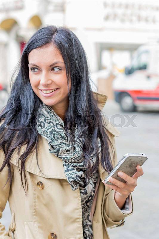A young woman writes a text message on his mobile phone. communication with a smart phone, stock photo