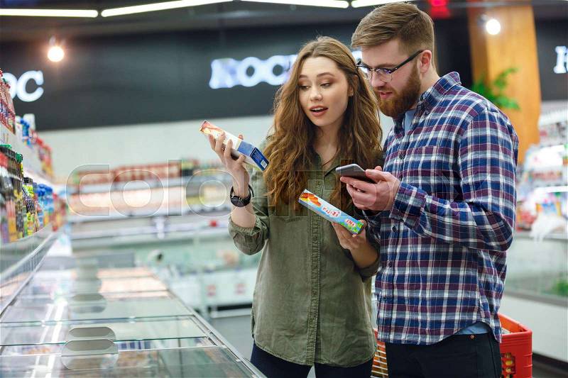 Bearded man and cute brunette woman talking about buying products in mall, stock photo