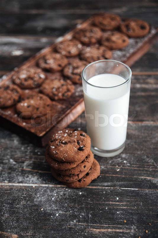Image of cookies on desk on dark wooden table at bakery with milk, stock photo