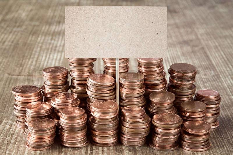 Blank sign with stacks of copper coins (Euro cents) , stock photo