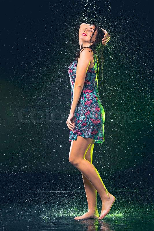 Young beautiful woman with splash of rain. Studio shot, stock photo