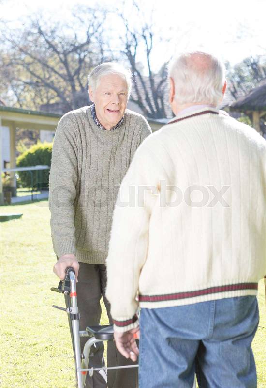 Couple of elderly friends in the garden, stock photo