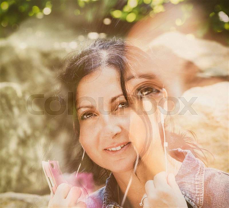 Woman hearing music outdoor, stock photo