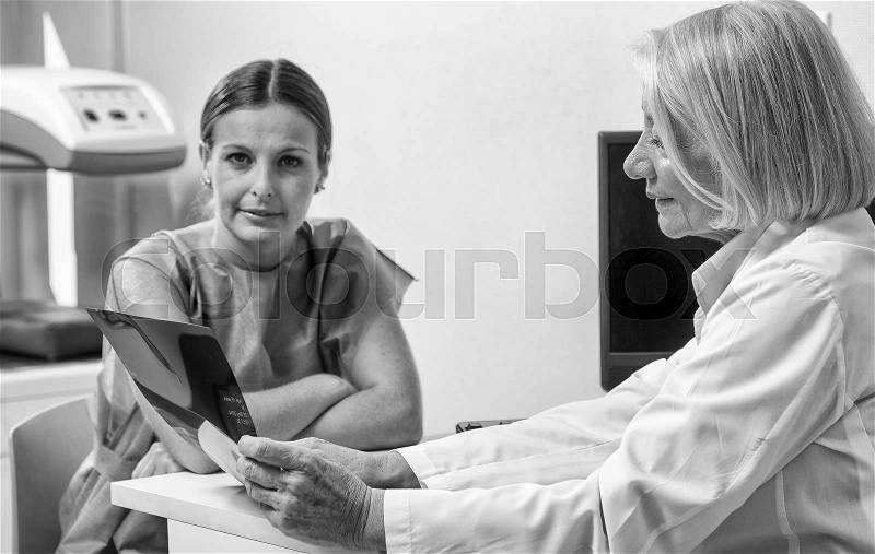 Expert female doctor with patient in hospital, stock photo