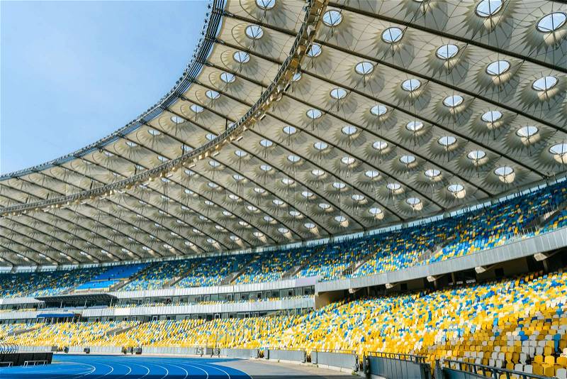 Rows of yellow and blue stadium seats on olympic stadium, stock photo
