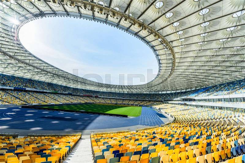 Rows of yellow and blue stadium seats on soccer field stadium, stock photo