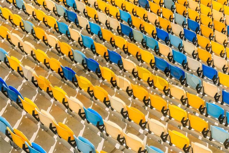 Elevated view of rows of yellow and blue stadium seats background, stock photo