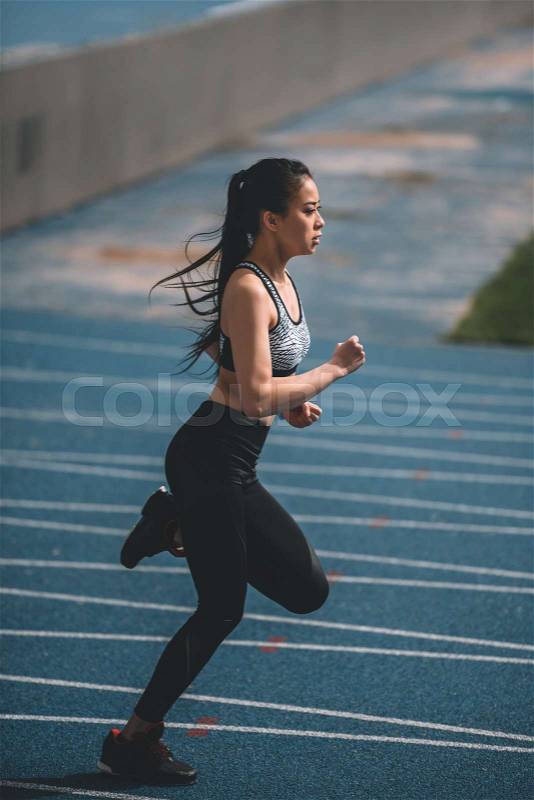 Asian sportswoman training on running track stadium, young girl running concept, stock photo