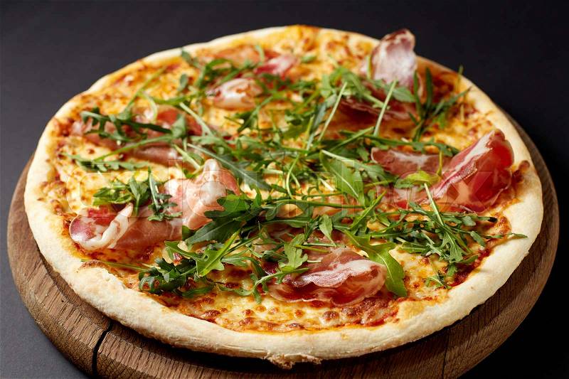 Hot pizza Prosciutto on a rustic wooden table. Italian food, stock photo