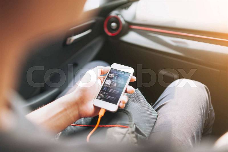 Man connecting phone to the car media system, stock photo
