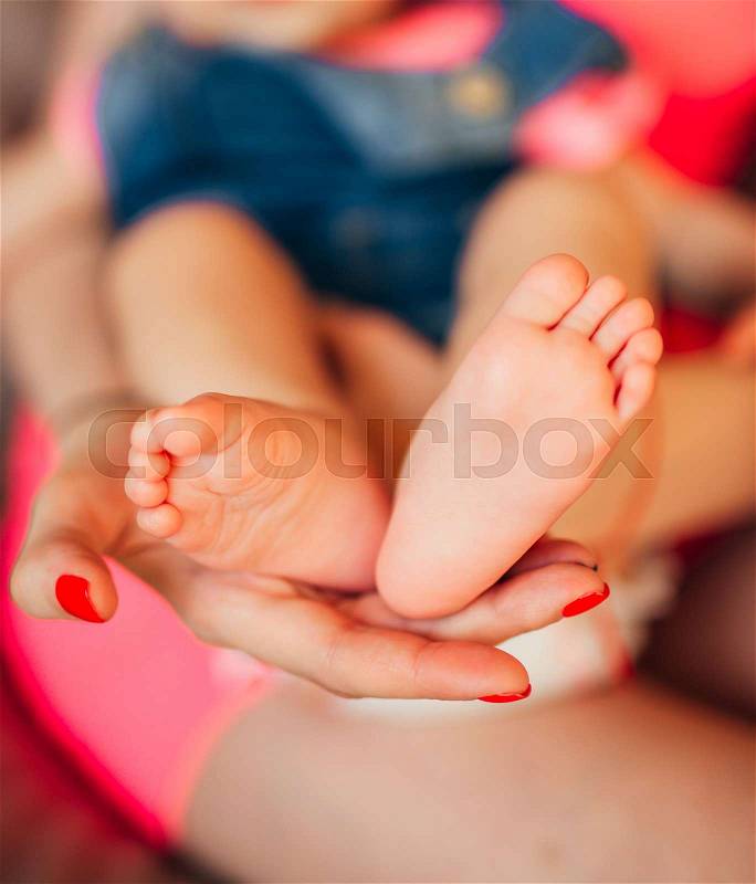 Little legs of the child, lies on the hands of the parents. Newborn baby, stock photo