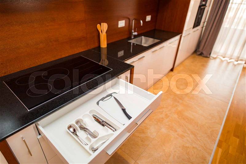 Cutlery in a drawer in the kitchen. Kitchen drawer in the kitchen. The interior of the kitchen room of the apartment, stock photo