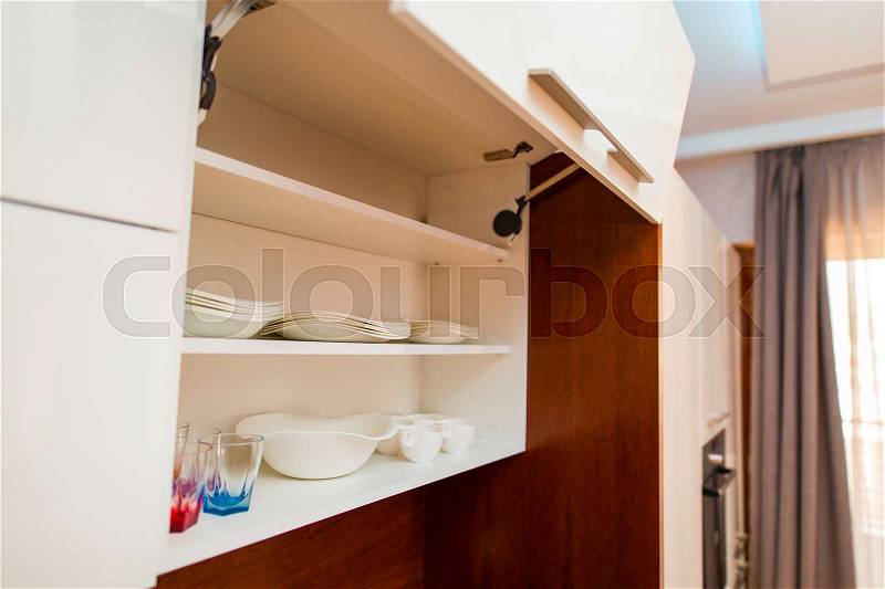 The plates in the kitchen. Cupboards in the kitchen. Kitchen room in the apartment, stock photo