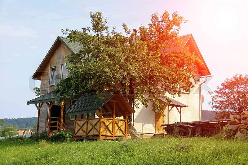 Modern cottage with porch and veranda in sunlight. Carpathians, Ukraine, stock photo