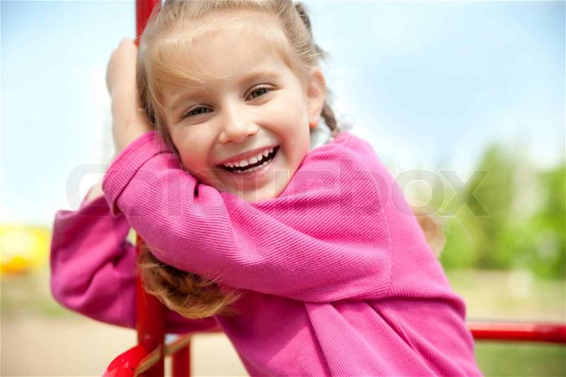 Cute little girl smiling in a park close-up, stock photo