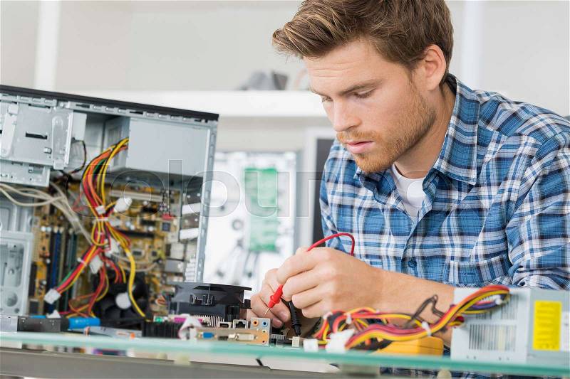Computer engineer fixing motherboard, stock photo