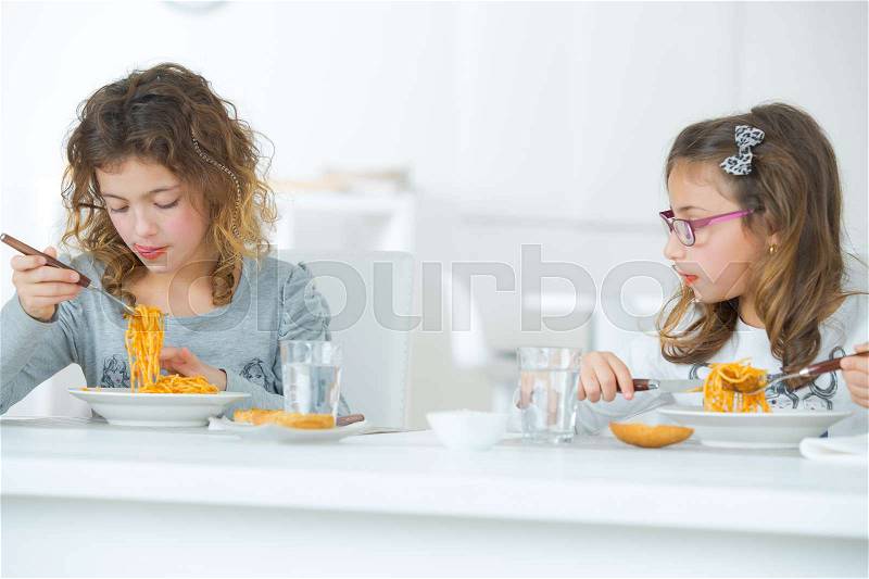 Kids eating pasta, stock photo
