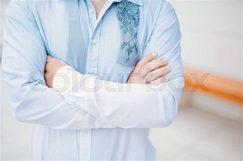 Male hands crossed on chest. Hands of the groom on the chest, stock photo