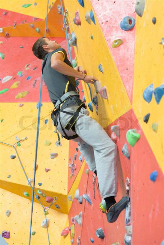 Man climbing indoor wall, stock photo