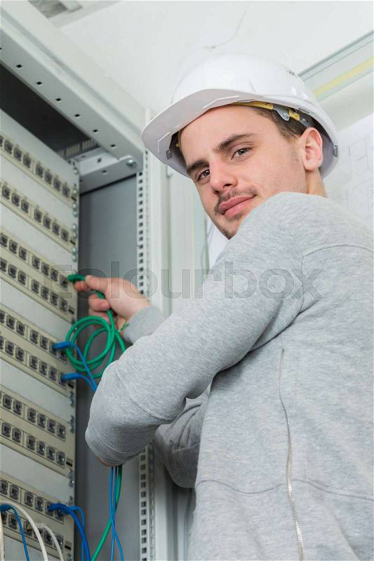 Young professional electrician at work in building, stock photo