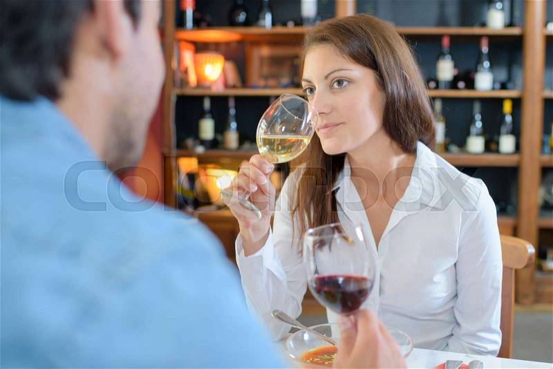 Couple in restaurant, woman drinking wine, stock photo