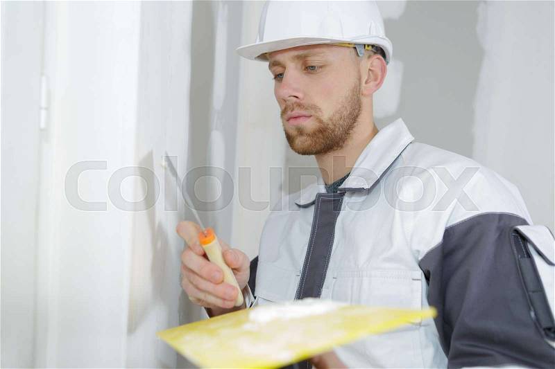 Worker spreading plaster to wal, stock photo