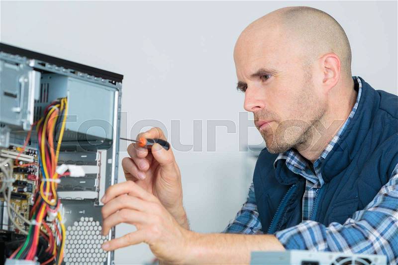 Computer specialist use screwdriver to repair hardware, stock photo