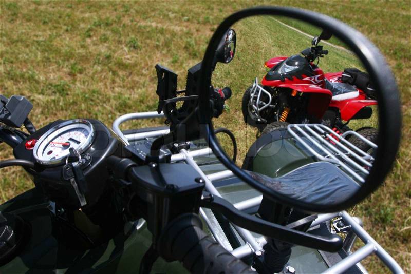 Red quad bike in rear view mirror, stock photo