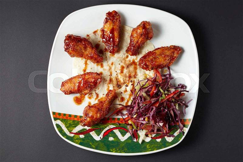 Chicken wings in Mexican style. Mexican food. Mexican cuisine. Studio shot on dark or black background, stock photo