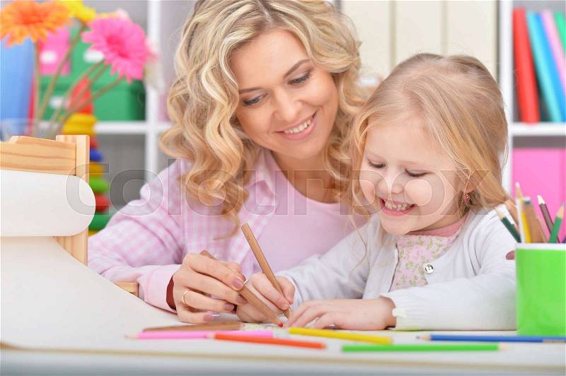 Mom and daughter draw at the table, stock photo