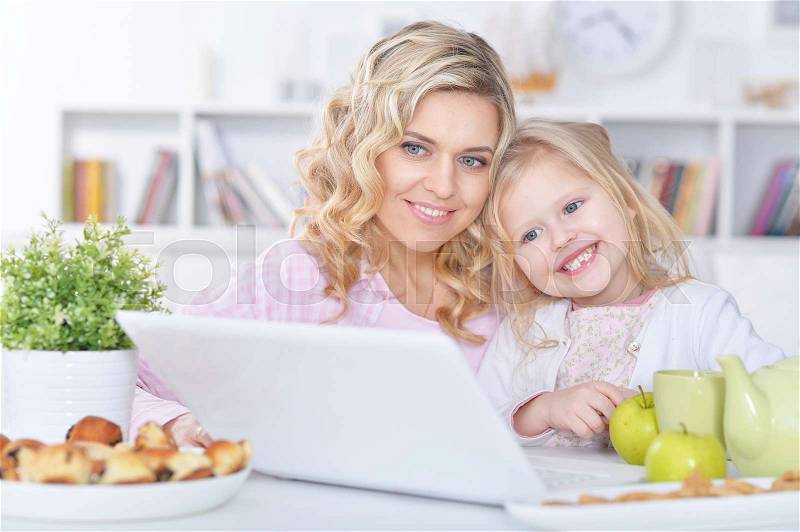 Mom and daughter at the table in the room, stock photo