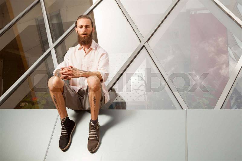 Hipster posing in front of office building. Modern start up company, stock photo