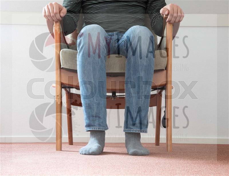 Man sitting in armchair, slightly creepy setting, stock photo