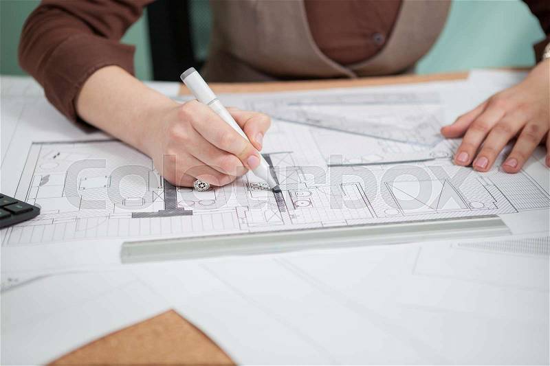 Architect woman at her table drawing on blueprints. Business and creativity. Architecture job, stock photo