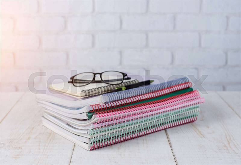 Spiral bound notebooks with glasses on wood table,office desk, stock photo