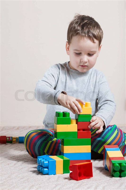 Playing little boy with colored cubes, stock photo