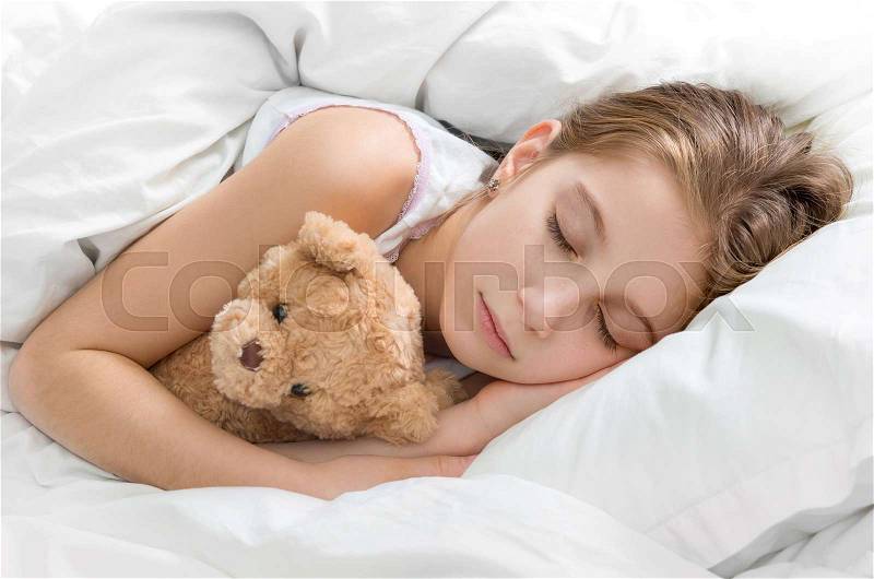 Amazing child napping and hugging her teddy bear in sleep, calm and peaceful, stock photo