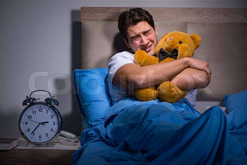 Young man scared in bed, stock photo