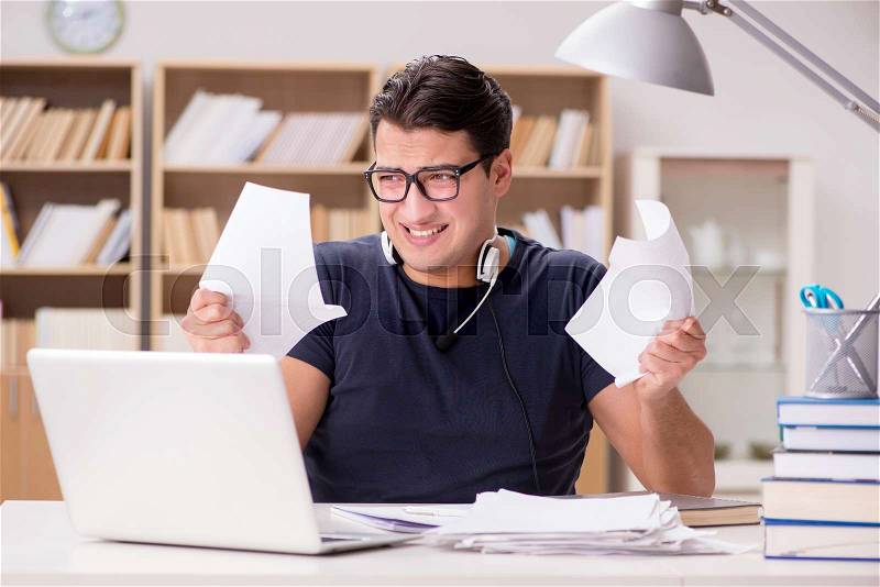 Angry man tearing apart his paperwork due to stress, stock photo