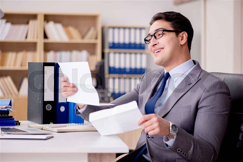 Businessman receiving letter envelope in office, stock photo