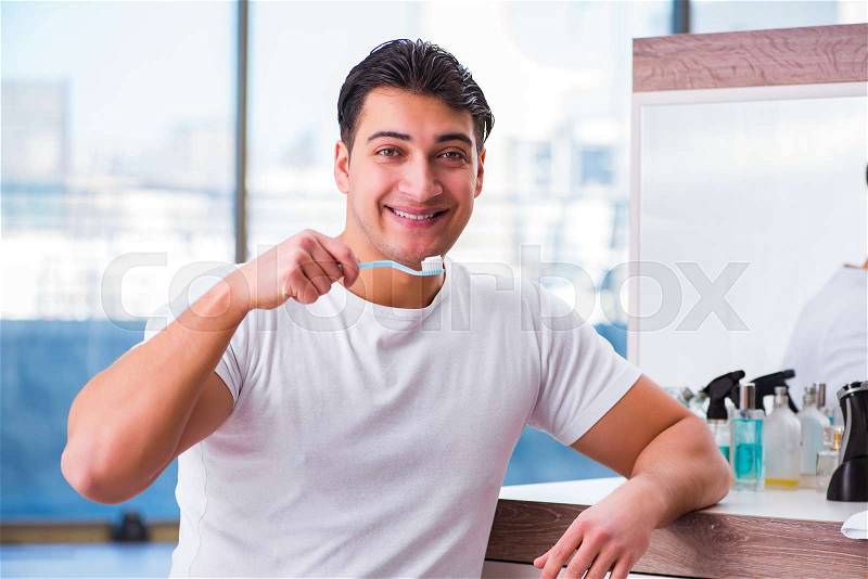 Handsome man brushing teeth in the morning, stock photo