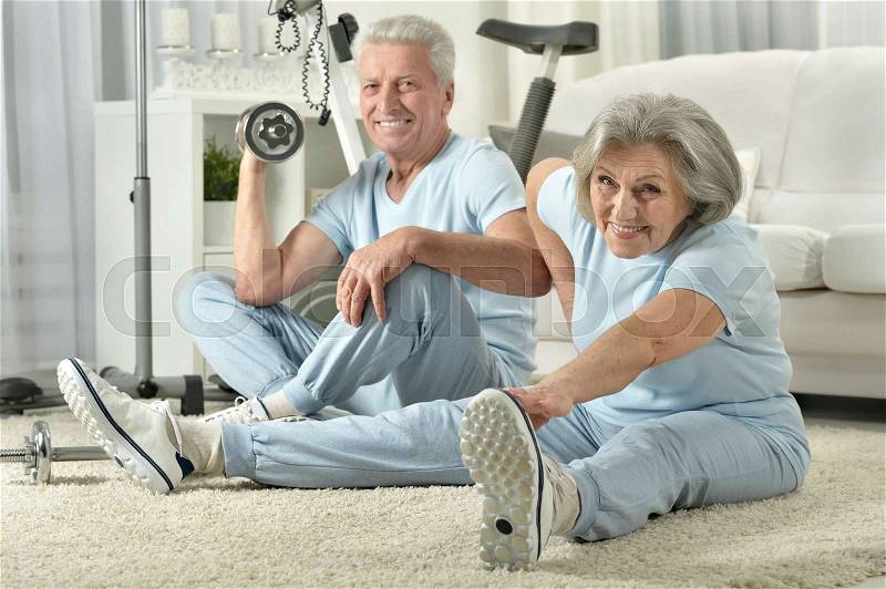 Happy elderly man doing sports at home, stock photo