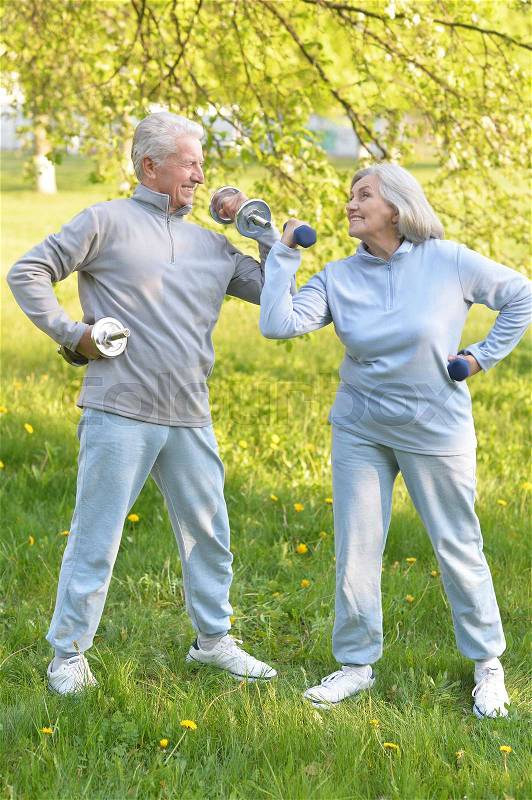 Old couple is doing sports on nature in summer, stock photo