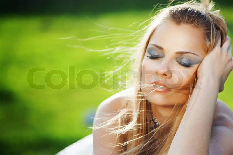 Portrait of a bride dreaming over fesh green grass, stock photo
