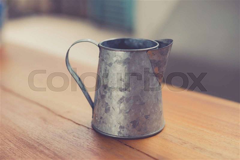 Stainless pitcher for make coffee on wood background made with retro filter, stock photo