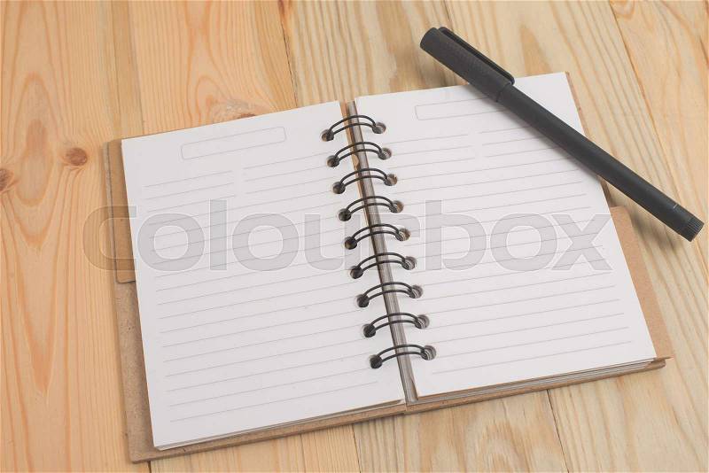 Spiral notebook on wood background, stock photo