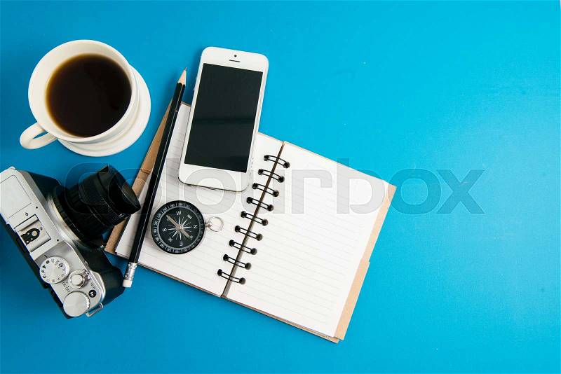 Creative flat lay photo of workspace desk with coffee, blank notebook, smartphone and film camera with copy space background, minimal styled, stock photo