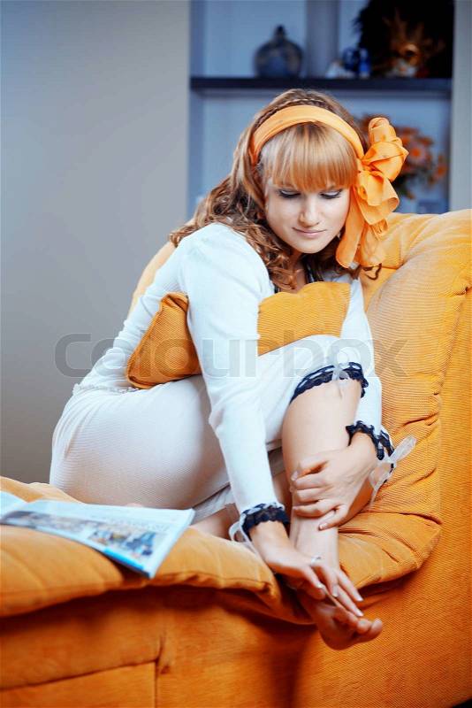 Portrait of cute pin-up housewife resting on sofa at home 